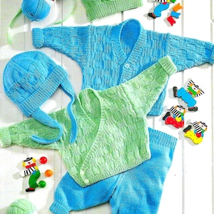 Puede incluir: Un conjunto de ropa de punto para bebé en azul y verde. El conjunto incluye un cárdigan, pantalones y un gorro. El cárdigan tiene cierre de botón y un patrón texturizado. Los pantalones son lisos y el gorro tiene una parte superior puntiaguda y una corbata larga.