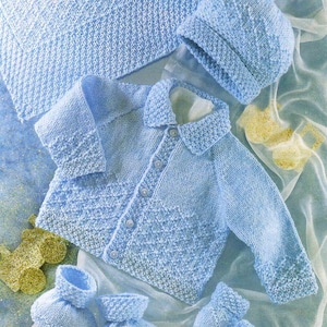 May include: A knitted baby outfit in light blue, including a cardigan, hat, and booties.