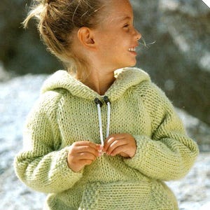 May include: A light green knitted hoodie with a drawstring hood and a front pocket. The hoodie is made with a simple stitch pattern and has a relaxed fit.