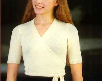 May include: A white wrap-style knitted top with short sleeves and a tie at the waist.