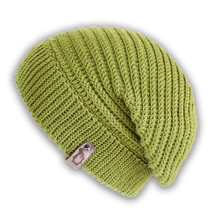 Könnte beinhalten: Eine grüne Strickmütze mit einem braunen Lederflicken mit einem Logo. Die Mütze hat eine lockere Passform und eine gerippte Textur.