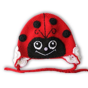 Può includere: Cappello di coccinella rosso all'uncinetto con dettagli in crochet bianco e dettagli ricamati neri. Il cappello ha una stringa di cravatta.