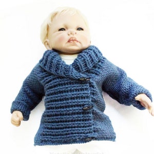 May include: A blue knitted cardigan with a shawl collar and button closure. The cardigan is made with a textured stitch and has a relaxed fit.