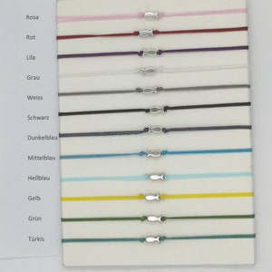 Könnte beinhalten: Ein Set mit 12 bunten Armbändern mit einem silbernen Fisch-Anhänger. Die Armbänder sind auf einem weißen Hintergrund mit den Farbnamen auf der linken Seite abgebildet.
