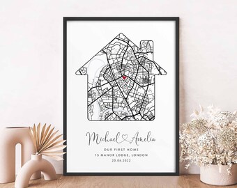 May include: A black and white house-shaped map print with a red heart marking the location of 13 Manor Lodge, London. The text below the map reads "Michael & Amelia, Our First Home, 13 Manor Lodge, London, 20.06.2022".