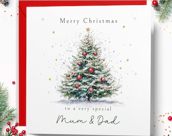 May include: A square white Christmas greeting card featuring a watercolour illustration of a decorated pine tree with red ornaments and gold ribbon. The text reads Merry Christmas to a very special Mum & Dad in dark green lettering.