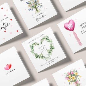 May include: A selection of greeting cards with different designs. Some cards display floral arrangements, a heart-shaped balloon, and the text "Happy 50th Birthday". Other cards include messages such as "To a Very Special Grandma" and "Congratulations Lewis and Becky".
