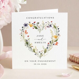 Engagement greeting card personalised with the couples names and date featuring a wildflower heart wreath