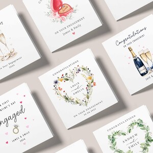 May include: A collection of engagement and congratulations cards. The cards feature watercolor illustrations of champagne, floral wreaths, and ring boxes. Text includes names, dates, and phrases like "On Your Engagement" and "Congratulations."