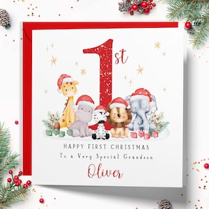 Op de afbeelding: Een vierkante wenskaart met een groot rood cijfer 1 en de tekst "Happy First Christmas To a Very Special Grandson Oliver". Het ontwerp bevat illustraties van een giraf, nijlpaard, zebra, leeuw en olifant die kerstmutsen dragen.