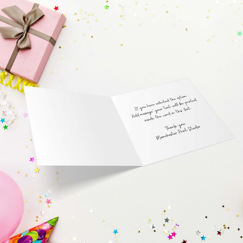May include: An open greeting card with text, surrounded by party decorations. The card's interior displays a message about custom text printing. A pink gift box with a brown ribbon and a pink balloon are also visible.