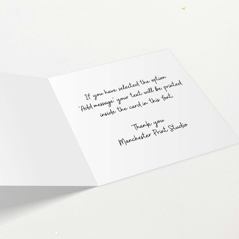 May include: An open white greeting card with black handwritten text. The text reads: "If you have selected the option 'Add message' your text will be printed inside the card in this font. Thank you Manchester Print Studio."