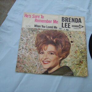 May include: A vintage 45 RPM record by Brenda Lee. The record cover features a photo of Brenda Lee with the song titles "He's Sure To Remember Me" and "When You Loved Me". The record label is Decca 31654.