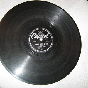 May include: Black vinyl record with a white label featuring the Capitol Records logo and the song title "Small Batch o' Wood" by Freddie Slack and His Orchestra. The record number is 172.