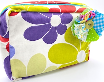 Cosmetic book bag with a fabric flower