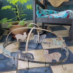 May include: A metal pot rack with hooks shaped like farm animals. The rack is painted white with rust accents and features a variety of animals including sheep, cows, and horses.