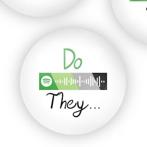 May include: Three white round buttons with green, white, and black stripes and a Spotify logo. The buttons have the text "Does She...", "Does He...", and "Do They..." written in black.