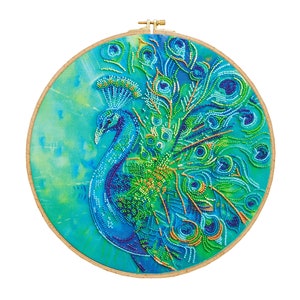 K&ouml;nnte beinhalten: Ein runder Stickrahmen mit einem Pfauenmotiv. Der Pfau ist aus blauen, gr&uuml;nen und goldenen Perlen gefertigt. Der Hintergrund ist ein hellblauer und gr&uuml;ner Aquarell-Wasch.