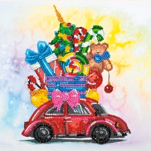 Op de afbeelding: Een rode speelgoedauto met een kerstboom, cadeaus, snoepstokken en een teddybeer erop. De auto is versierd met een roze strik.