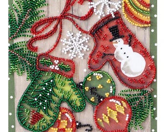 May include: A Christmas-themed beaded artwork featuring two mittens, one red with a snowman and one green with pine needles, surrounded by red and green ornaments and snowflakes.