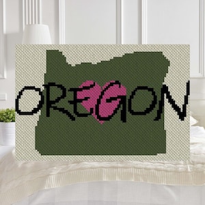 May include: A green outline of the state of Oregon with a pink heart in the center and the word "OREGON" in black letters.