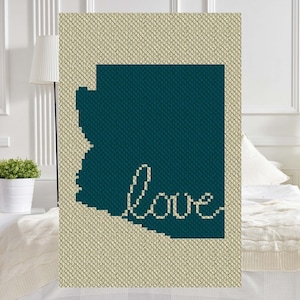 May include: A teal blue crochet blanket with the outline of the state of Arizona and the word "love" written in white yarn.