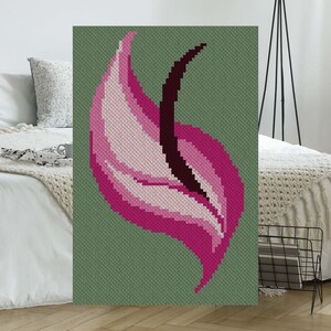 May include: A pink and white flower with a dark brown stem, embroidered on a green background.