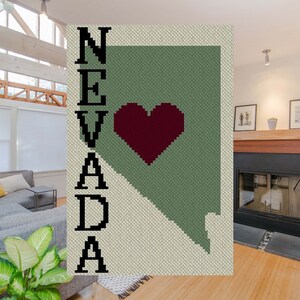 May include: A crochet pattern of the state of Nevada with a red heart in the center and the word "NEVADA" written vertically on the left side.
