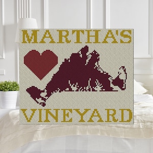 May include: A beige canvas with a red heart and a maroon outline of Martha's Vineyard. The words "Martha's Vineyard" are in gold lettering.