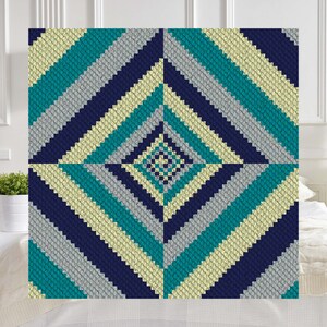 May include: A crocheted square with a geometric pattern in shades of teal, blue, gray, and cream.