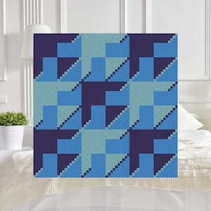 May include: A geometric pattern woven throw blanket in shades of blue and purple. The blanket features a repeating pattern of squares and triangles.
