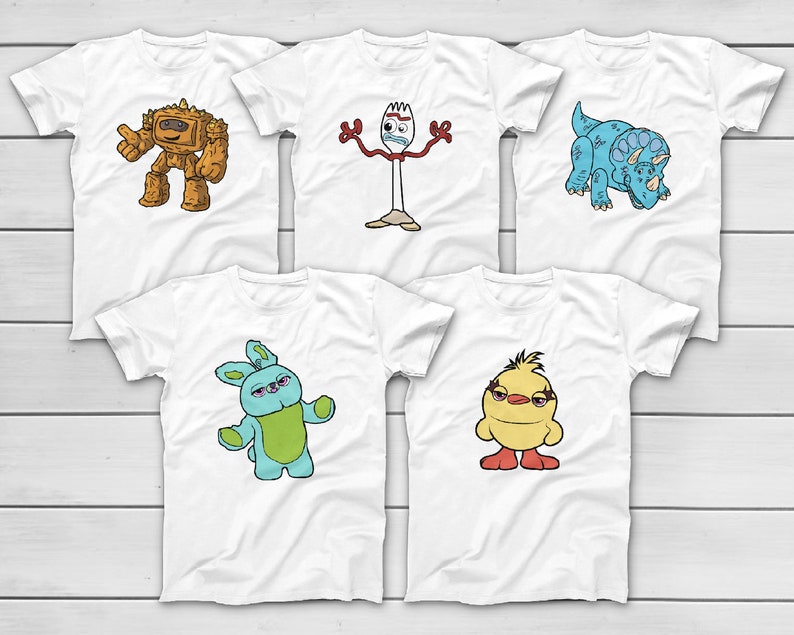 Puede incluir: Cinco camisetas blancas con dise&ntilde;os de personajes de dibujos animados coloridos. Los dise&ntilde;os incluyen un robot, una figura en forma de tenedor, un dinosaurio azul, un conejo azul y verde y un pollito amarillo. Cada camiseta tiene cuello redondo y mangas cortas.
