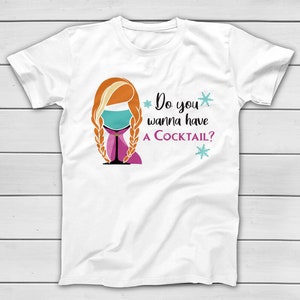 May include: White t-shirt with a graphic of a woman's face with orange hair in braids, a cocktail glass, and the text "Do you wanna have a Cocktail?" in black and purple. Two blue snowflakes are also included in the design.