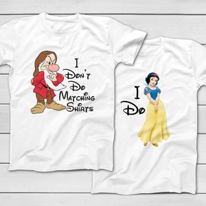 May include: Two white t-shirts with Disney characters and text. One shirt features Grumpy with the text "I Don't Do Matching Shirts." The other shirt shows Snow White with the text "I Do."