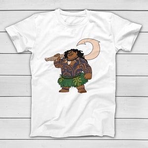 Puede incluir: Camiseta blanca con una ilustraci&oacute;n de dibujos animados de un personaje polinesio. El personaje tiene tatuajes, una falda de hierba verde y un gran gancho. El personaje sonr&iacute;e y sostiene el gancho sobre su hombro. El dise&ntilde;o est&aacute; centrado en la camiseta.