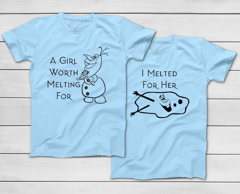 以下が含まれることがあります： 2つの水色のTシャツ。片方には「A GIRL WORTH MELTING FOR」の文字と漫画の雪だるまが描かれています。もう片方には「I MELTED FOR HER」の文字と溶けた雪だるまが描かれています。
