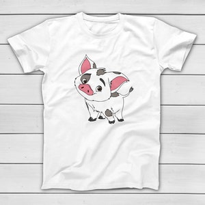 Puede incluir: Camiseta blanca con una ilustraci&oacute;n de cerdo de dibujos animados. El cerdo tiene un cuerpo blanco con manchas negras y grises, orejas rosas y un hocico rosa. El cerdo est&aacute; sonriendo y tiene ojos negros. La camiseta es de material suave.