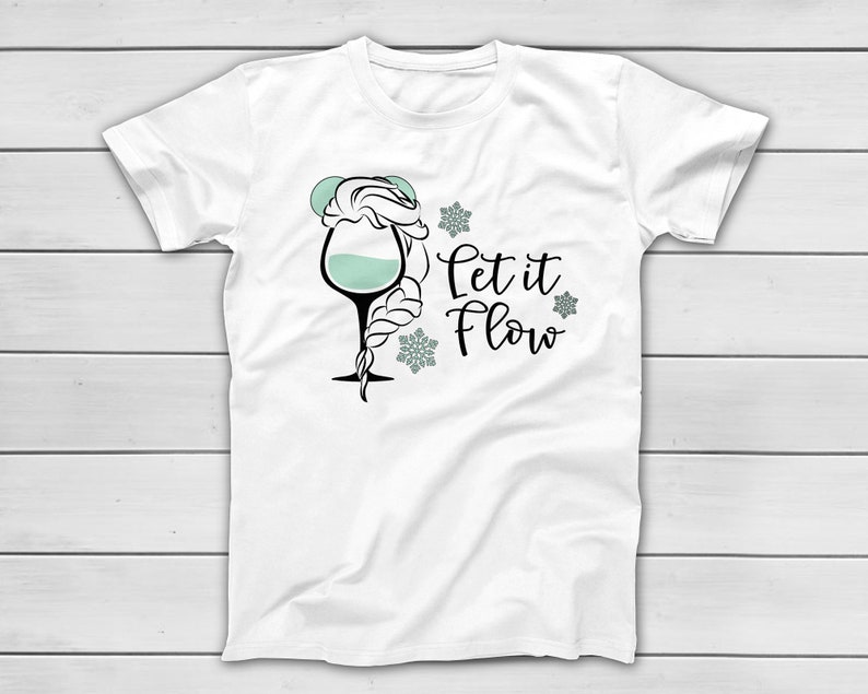 May include: White t-shirt featuring a whimsical design of a wine glass with a braided hairstyle and the text "Let it Flow" in black script. The glass is filled with a light teal liquid, and snowflakes surround the text.