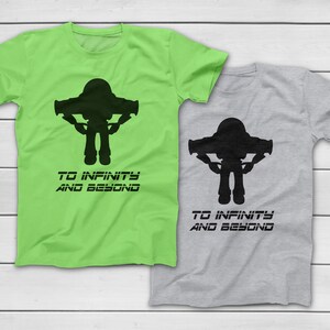 May include: Two short-sleeved t-shirts, one lime green and one gray, each featuring a black silhouette of a space ranger with the text "TO INFINITY AND BEYOND" below. The shirts are likely made of cotton.