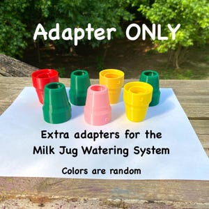 May include: A collection of colorful plastic adapters in red, green, pink, and yellow. The text on the image reads "Adapter ONLY" and "Extra adapters for the Milk Jug Watering System. Colors are random."