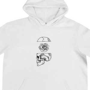 Op de afbeelding: Witte hoodie met een zwart-witte afbeelding van een schedel met een roos erin. De afbeelding is gecentreerd op de hoodie.