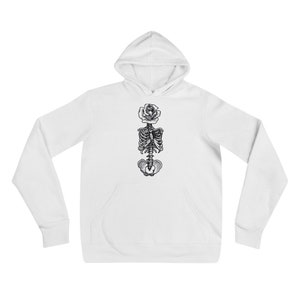 Op de afbeelding: Witte hoodie met een zwart-witte illustratie van een skelet met een roos die uit zijn borst groeit.