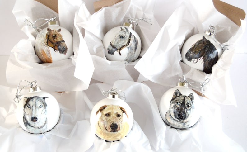 Pode incluir: Seis enfeites de Natal redondos brancos com imagens pintadas de animais. Os enfeites apresentam um cavalo castanho e branco, um cavalo cinza, um cavalo castanho, um c&atilde;o cinza e branco, um c&atilde;o amarelo e um lobo cinza e branco.