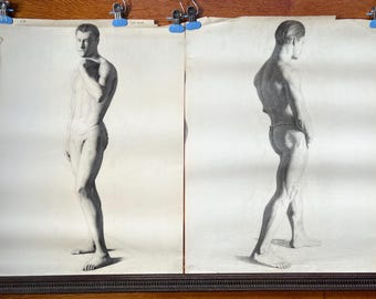 May include: Two pencil sketches of a male figure. One shows a frontal view, the other a rear view. The drawings are on aged paper, held by blue clips. The sketches are framed in a dark brown frame.