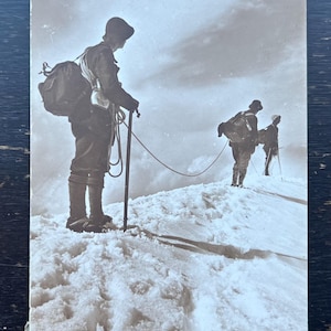 May include: A white ceramic mug with a black handle and the text "But First, Coffee" in a black, bold font. The mug is on a white surface.