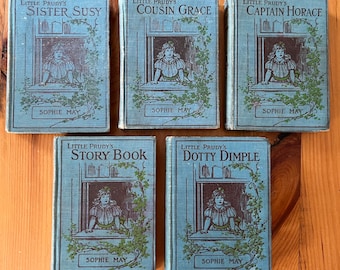 May include: Five vintage children's books with blue covers and illustrations of girls in windows. The titles are "Little Prudy's Sister Susy", "Little Prudy's Cousin Grace", "Little Prudy's Captain Horace", "Little Prudy's Story Book", and "Little Prudy's Dotty Dimple". All books are by Sophie May.