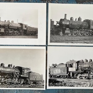 May include: Four black and white photographs of steam locomotives. Each image shows a different locomotive, with details of the wheels, smokestacks, and cabs visible. The photographs are arranged in a square format.