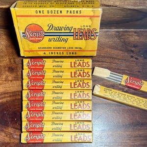 May include: A collection of Scripto drawing leads in yellow packaging. The box and individual packs feature the Scripto logo and text indicating the leads are 4 inches long. The packaging is vintage.