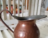 Small hand-hammered copper and brass pitcher. I adore the symmetrical pattern by the hammer. This size indicates it was likely a creamer.