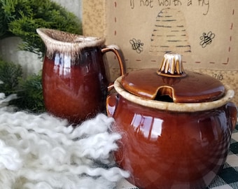 Fabuloso azucarero y cremera de mediados de siglo. Este juego de Hull de los años 50 lo lucirá con orgullo en su cocina de estilo rústico.